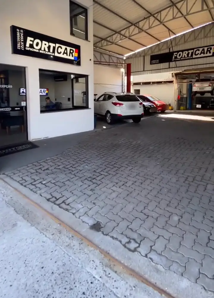 Recepção e galpão da Fortcar Oficina Mecânica, com as placas FORTCAR e carros em atendimento